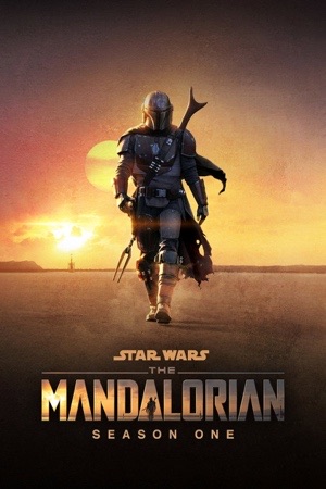 The Mandalorian in silhouette walking across a desert ridge at sunset.