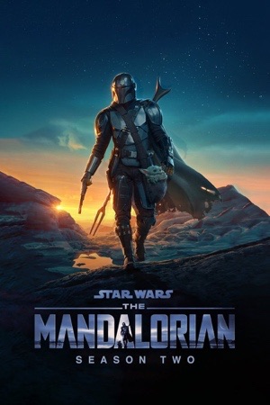 The Mandalorian standing on a dune at dusk in blue light.