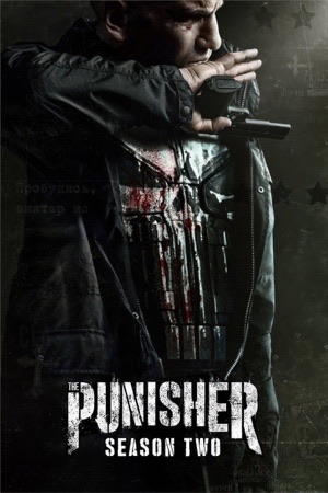 Jon Bernthal reloading a pistol, the white skull emblem showing through his torn shirt.